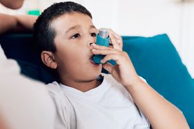 Boy using inhaler at home