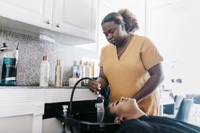 Black woman getting hair washed at salon