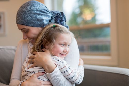 Young mom with cancer holds her daughter tightly