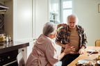 older man feeling stomach pain after eating food with wife 