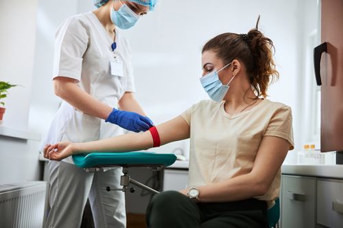 Woman getting blood drawn by doctor