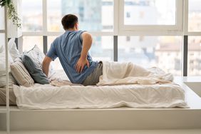 a man laying in bed experiencing painful sciatica symptoms