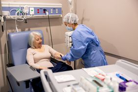 Nurse preparing a woman for chemotherapy