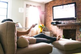 Woman lounging on couch watching TV