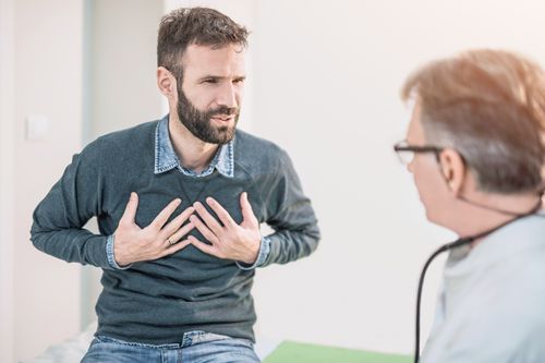 Mid adult male patient describing a chest pain to his doctor.