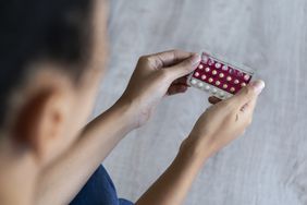 Close-up of woman's hand holding birth control pills