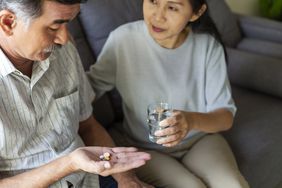 Senior woman giving her husband daily prescription medication