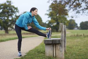 woman stretching in park during run