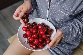 woman holding a bowl of cherries