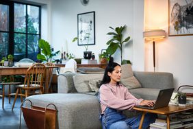 woman sitting in front of laptop in living room