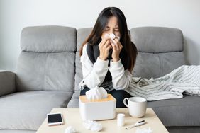 Person blowing nose on couch.
