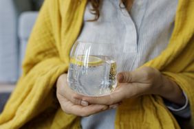 woman holding sparkling water with lemon slice