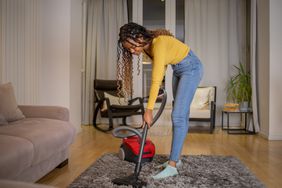 Woman cleaning floor with vaccuum cleaner