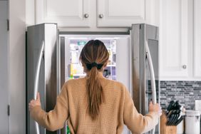 woman looking into refrigerator