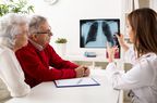 doctor showing elderly couple an x-ray of lungs 