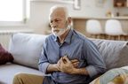 older man holding hands over heart due to chest pain