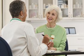 doctor giving older woman a prescription medication for lupus 