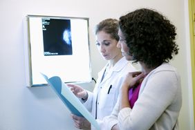 healthcare provider reading mammogram results to patient.