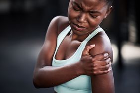 A black woman with muscle pain in her shoulder