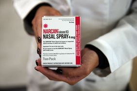 pharmacist holding naloxone/narcan nasal spray box