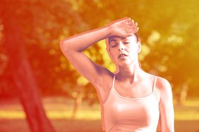 Hyperthermia - Young fitness woman resting after workout in nature