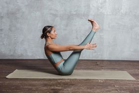 A woman practicing pilates on a yoga mat