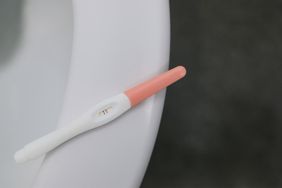 Positive Pregnancy Test Stick Lies On A Toilet Bowl