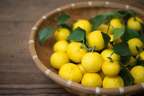 Organic Yuzu (Japanese citrus lemon) displayed in a traditional bamboo basket on a wooden table